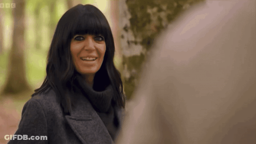 Woman In Grey Coat Smiling In Front Of Tree GIF