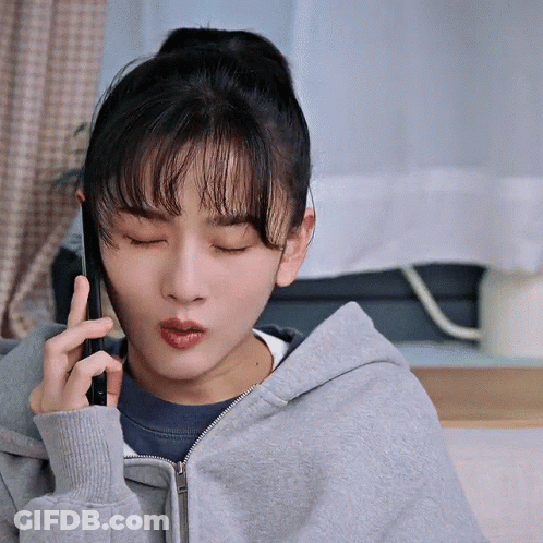 Woman In Grey Hoodie Talking On Phone Eyes Closed GIF
