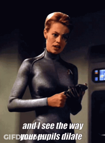 Woman In Grey Suit Saying Pupil Dilation GIF