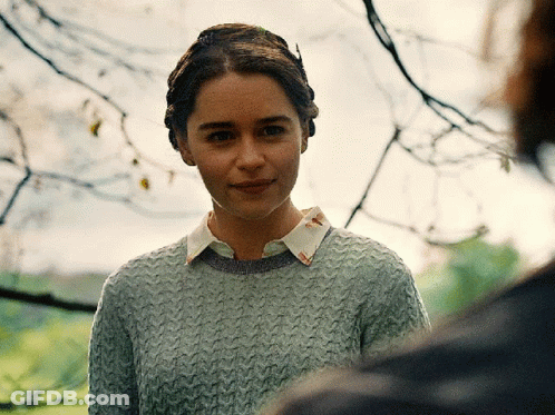 Woman In Grey Sweater And White Collar Looking At Camera GIF