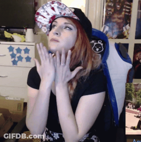 Woman In Hat And Black Shirt Hands On Chin GIF