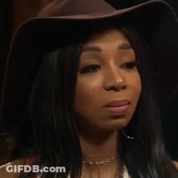 Woman In Hat And Earrings Looking At Camera GIF