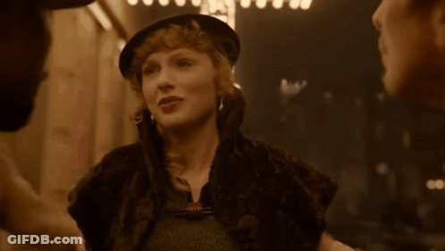 Woman In Hat And Fur Coat Talking To Man GIF