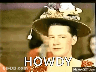 Woman In Hat And Red Dress Standing Before Crowd GIF