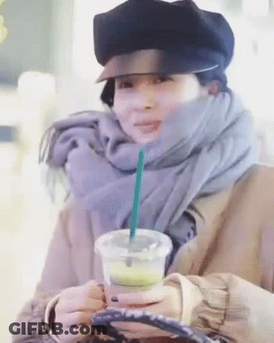 Woman In Hat And Scarf Holding Coffee With Straw GIF