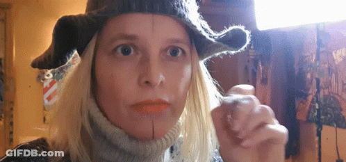 Woman In Hat And Scarf Looking At Camera GIF