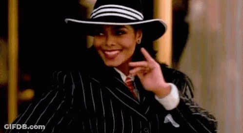 Woman In Hat And Striped Suit Smiling And Pointing GIF