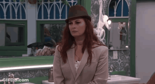 Woman In Hat And Suit At Sink GIF