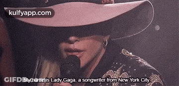Woman In Hat And Sunglasses Holding Microphone GIF