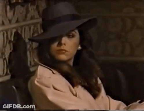 Woman In Hat And Trench Coat Sitting GIF
