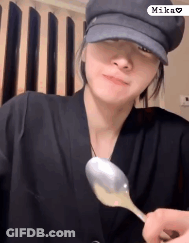 Woman In Hat Holding Spoon In Front Of Face GIF