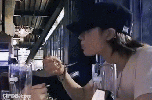 Woman In Hat Sitting At Table With Water And Fork GIF