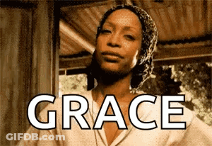 Woman In Head Scarf Standing In Front Of Grace Sign GIF