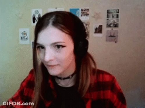 Woman In Headphones And Plaid Shirt Sitting By Wall GIF