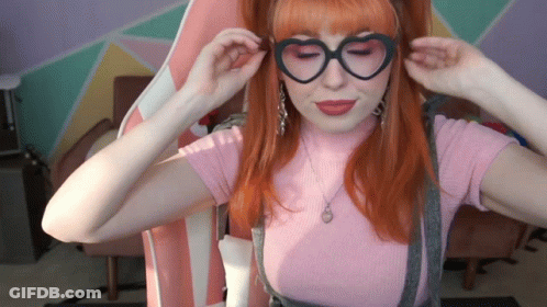 Woman In Heart-Shaped Glasses And Pink Top GIF