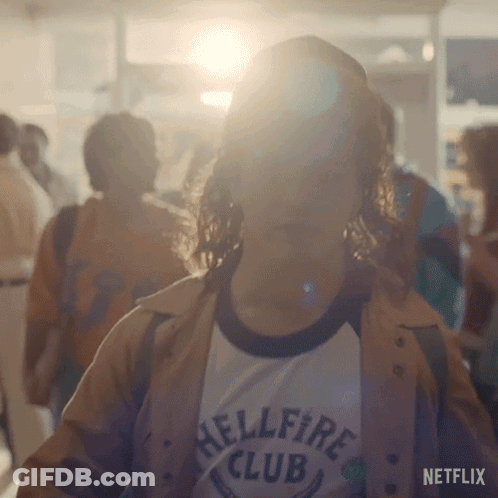 Woman In Hellfire Club T-Shirt Standing In Crowd GIF