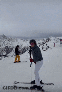 Woman In Helmet And Goggles Holding Ski Pole In Snow GIF