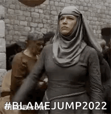 Woman In Hijab Standing In Crowd By Stone Wall GIF