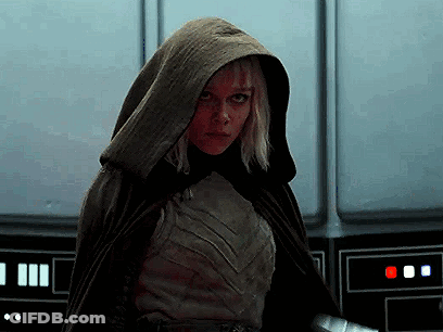 Woman In Hooded Cape Standing By Wall GIF