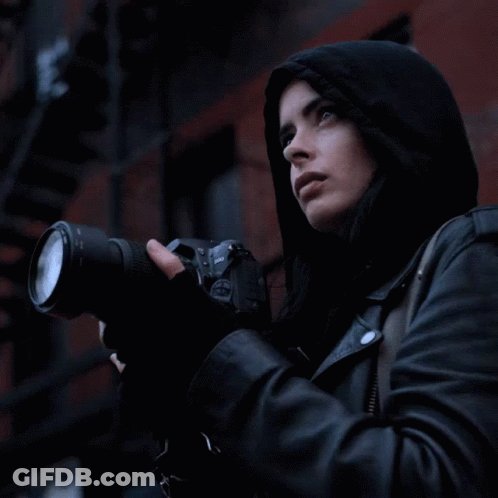 Woman In Hooded Jacket Holding Nikon Camera GIF