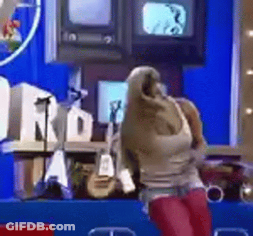 Woman In Hooded Jacket In Front Of Blue Wall GIF