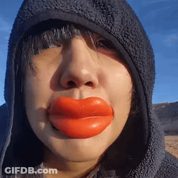 Woman In Hooded Jacket With Huge Red Lips GIF