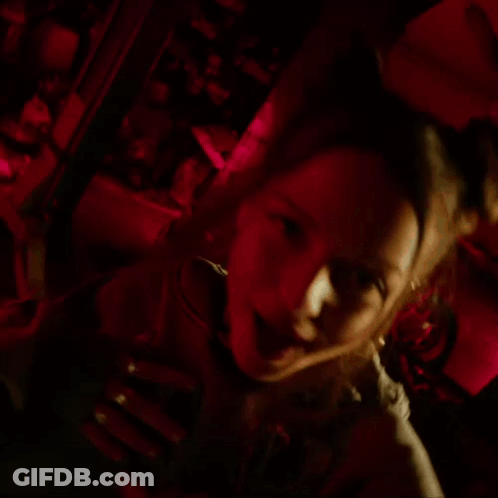Woman In Hoodie With Skulls In Dark Room GIF