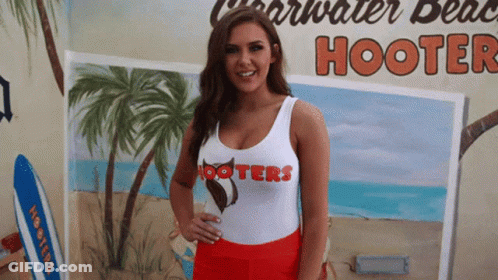 Woman In Hooters Tank Top In Front Of Mural GIF