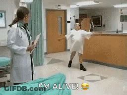 Woman In Hospital Gown Dancing As Doctor Looks On GIF