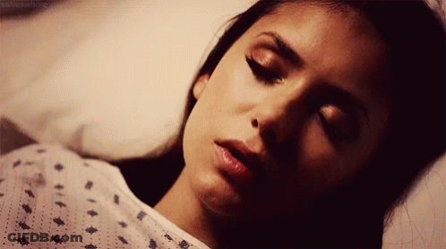 Woman In Hospital Gown Lying In Bed Eyes Closed GIF