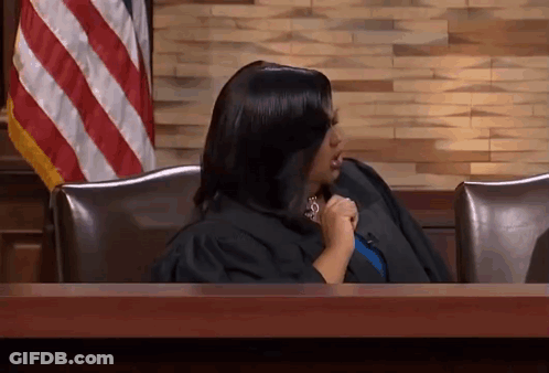 Woman In Judge's Robe Sitting At Table GIF