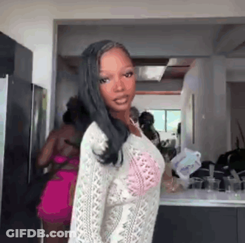Woman In Kitchen Wearing White Sweater And Pink Bra GIF