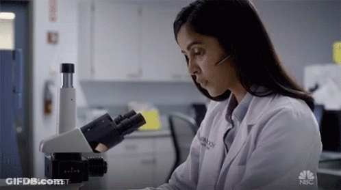 Woman In Lab Coat At Microscope With NBC Logo GIF