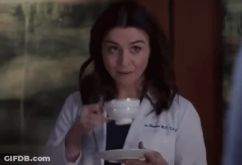 Woman In Lab Coat Holding Coffee Cup And Saucer GIF