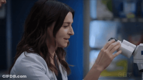 Woman In Lab Coat Looking Through Microscope GIF