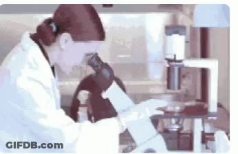 Woman In Lab Coat Looking Through Microscope GIF