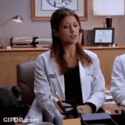 Woman In Lab Coat Sitting At Desk GIF
