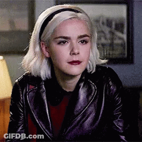 Woman In Leather Jacket And Headband Sitting In Room GIF