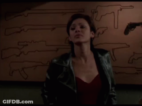 Woman In Leather Jacket In Front Of Guns Saying Yeah Right GIF