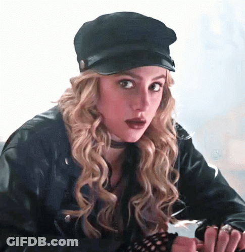 Woman In Leather Jacket Looking At Camera In Dark Room GIF