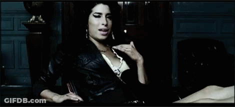 Woman In Leather Jacket Sitting By Statue GIF