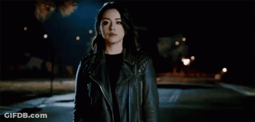 Woman In Leather Jacket Standing In Dark Street GIF