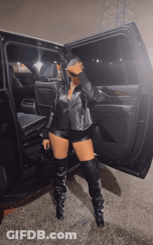 Woman In Leather Shorts And Thigh High Boots By Car GIF