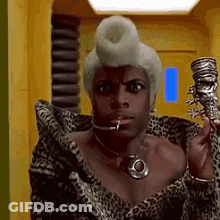 Woman In Leopard Print Coat And Wig Holding Skull GIF
