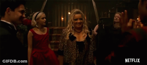 Woman In Leopard Print Dress Dancing With Two Men In Tuxedos GIF