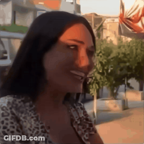 Woman In Leopard Print Shirt Smiling In Front Of Trees GIF