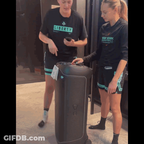 Woman In Liberty Shirt Next To Woman In New York Basketball Shirt GIF