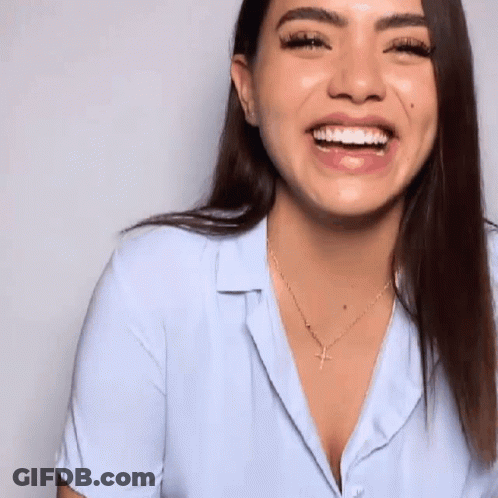 Woman In Light Blue Shirt And Gold Necklace Smiling GIF