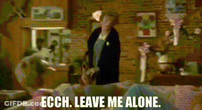 Woman In Living Room Next To Couch Saying Leave Me Alone GIF