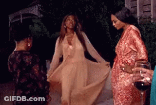 Woman In Long Dress Dancing With Two Women And Wine Holder GIF